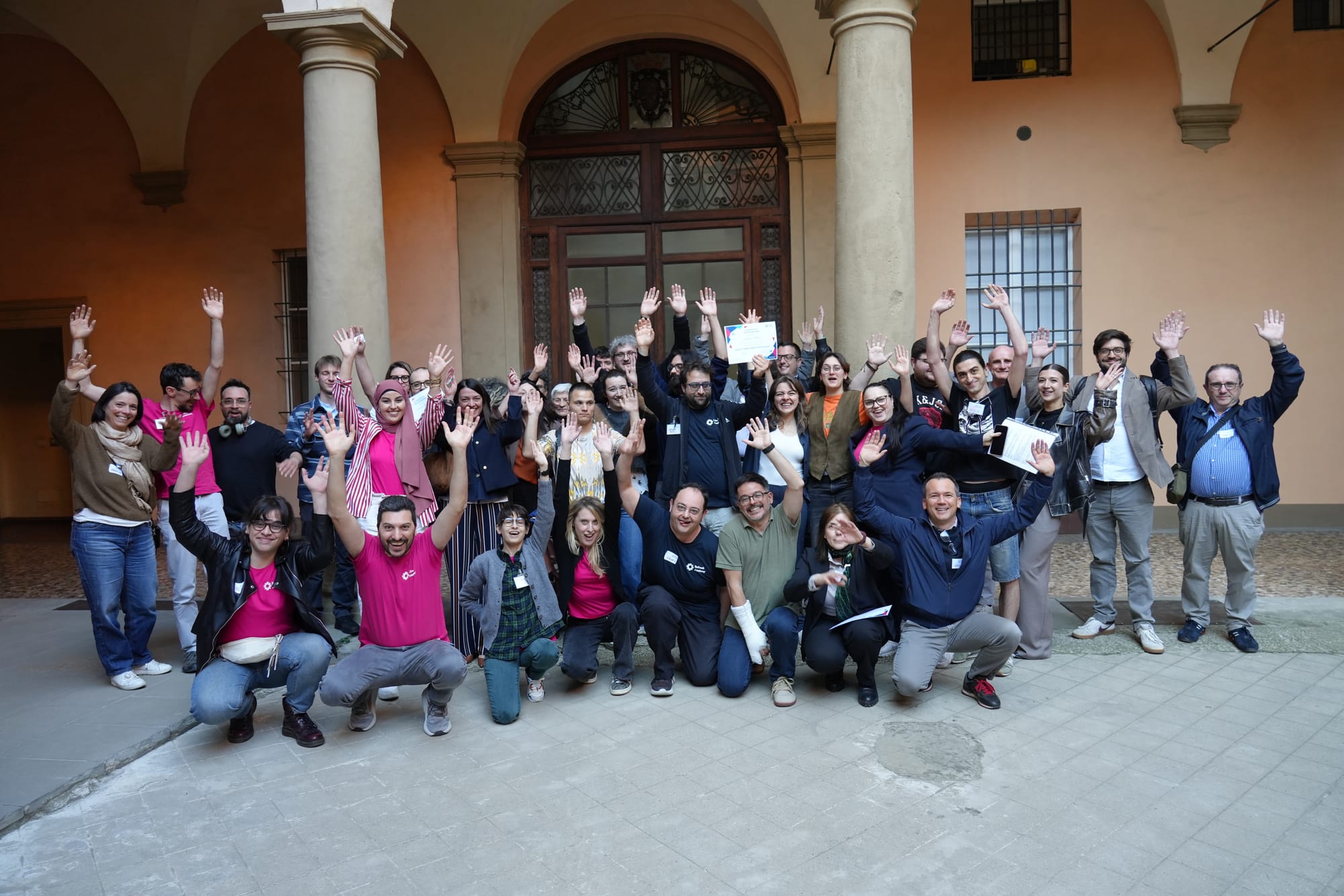 Specialist, team e partner di Refresh Academy salutano con le mani alzate nel cortile della sede