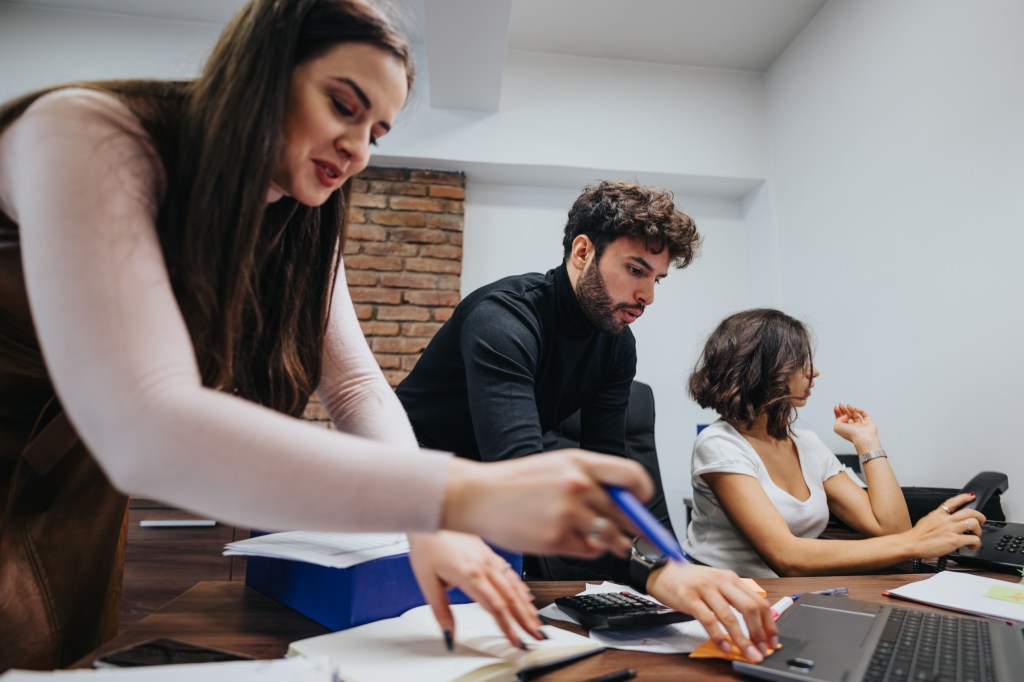 Focused professionals collaborating in a business meeting with laptops